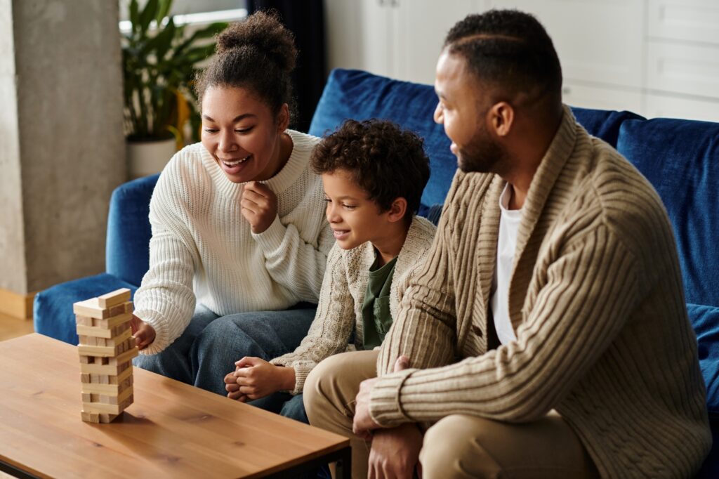 Family playing a tower block game on the couch. Happy family enjoying game time together. Fun indoor activities for families in West Chester, PA.