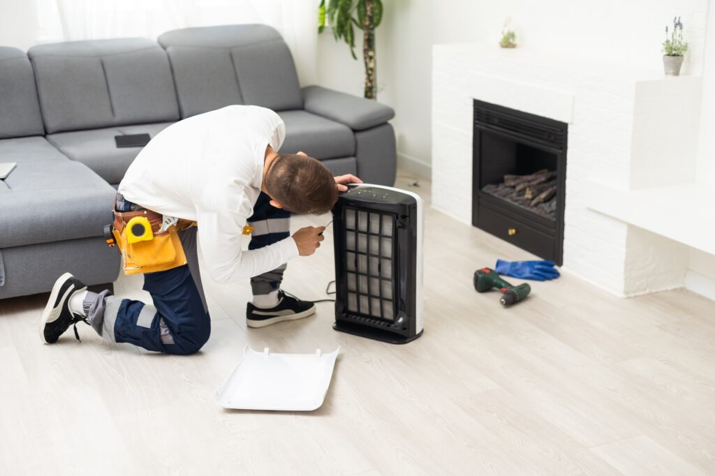 HVAC technician repairs an air purifier in a West Chester, PA home. Air purifier maintenance for healthy indoor air quality and home comfort systems.